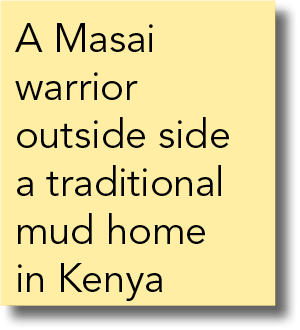 A Masai warrior outside side a traditional mud home in Kenya